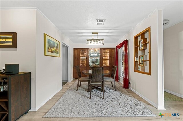 3921 Cripple Creek Dr, Temple, TX 76502 - dining space featuring light wood-style floors, crown molding, and baseboards