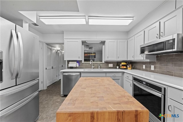 3921 Cripple Creek Dr, Temple, TX 76502 - kitchen with stainless steel appliances, a sink, wooden counters, tasteful backsplash, and a kitchen island