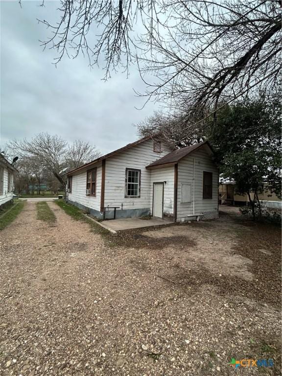 back of house featuring driveway and a patio area