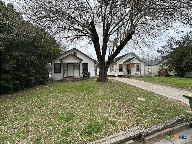 bungalow-style home featuring a front lawn