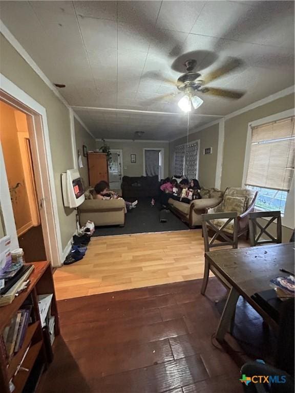 living room featuring crown molding, ceiling fan, and wood finished floors