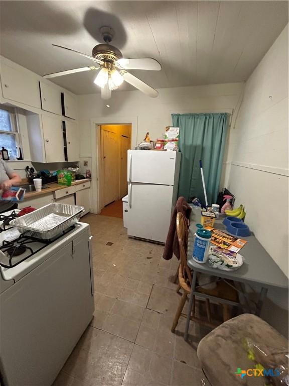 kitchen with ceiling fan, white appliances, and white cabinetry