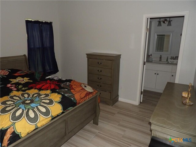 930 Redwood, Rockport, TX 78382 - bedroom with light wood-type flooring and connected bathroom