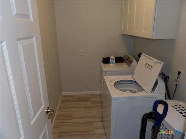 930 Redwood, Rockport, TX 78382 - washroom featuring cabinet space, washing machine and dryer, and light wood-style floors