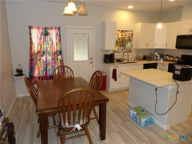 930 Redwood, Rockport, TX 78382 - kitchen featuring black appliances, light countertops, white cabinetry, tasteful backsplash, and hanging light fixtures