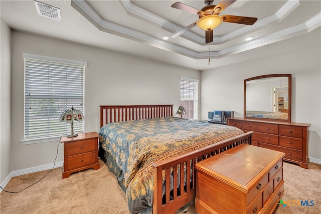 carpeted bedroom featuring ceiling fan, ornamental molding, and a tray ceiling