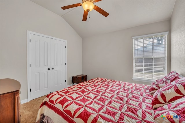 bedroom with ceiling fan, a closet, carpet floors, and lofted ceiling