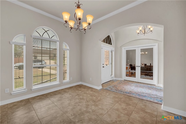 unfurnished dining area featuring french doors, an inviting chandelier, and ornamental molding