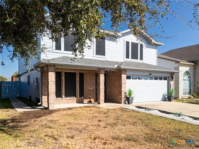 view of front of home featuring covered porch, a garage, and a front lawn