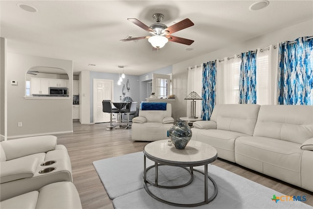 living room featuring ceiling fan and light hardwood / wood-style flooring