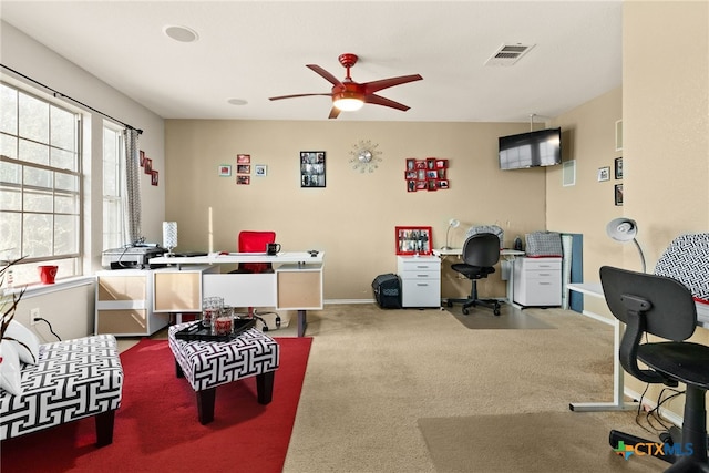 carpeted office space featuring ceiling fan and a healthy amount of sunlight