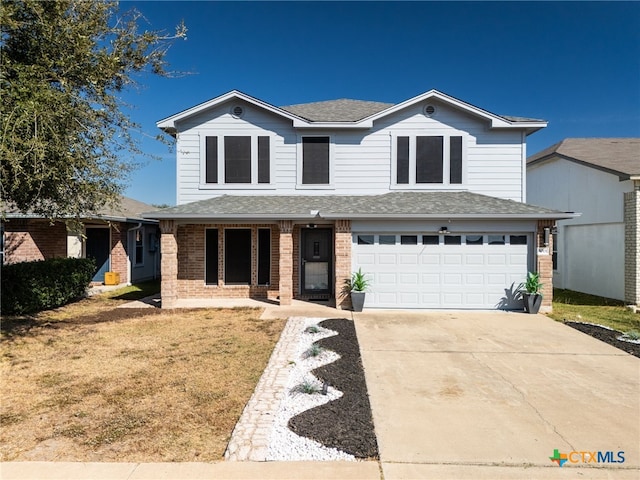 view of property with a porch, a garage, and a front yard