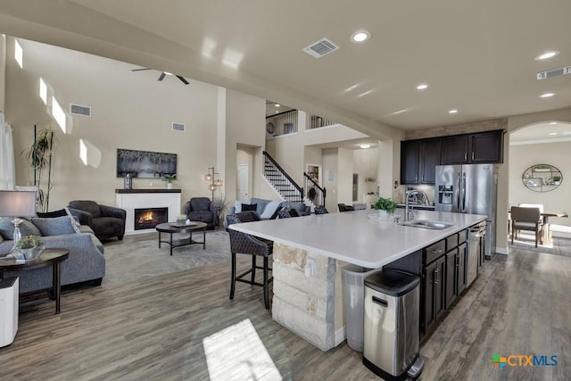 kitchen with open floor plan, visible vents, a lit fireplace, and a sink