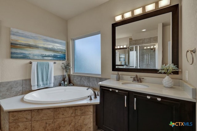 bathroom featuring vanity, a bath, and a stall shower