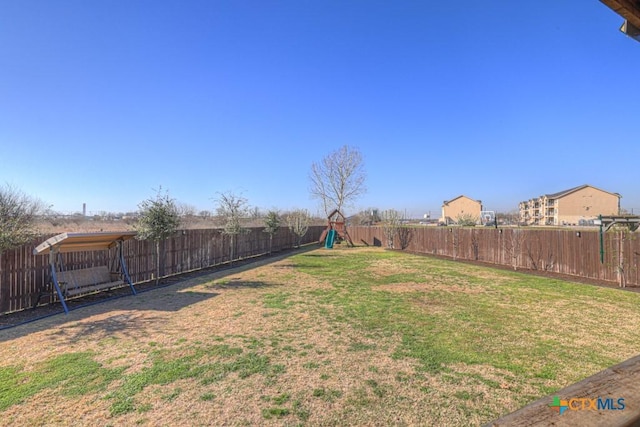 view of yard featuring a playground and a fenced backyard