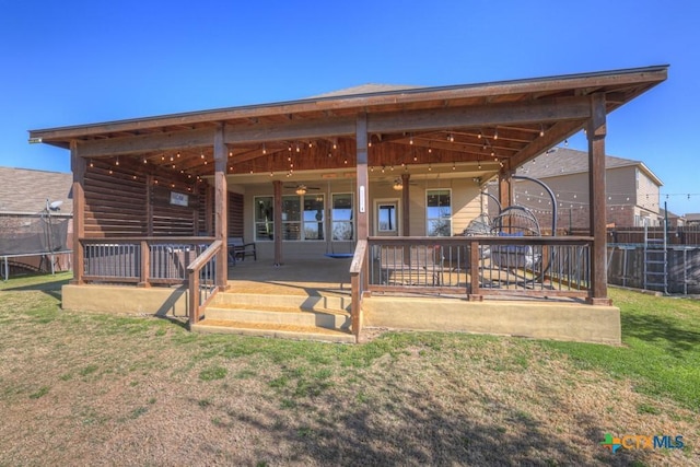 back of property featuring a yard, a patio area, a ceiling fan, and fence