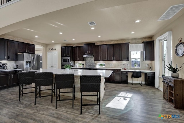 kitchen with visible vents, a kitchen breakfast bar, appliances with stainless steel finishes, and light countertops