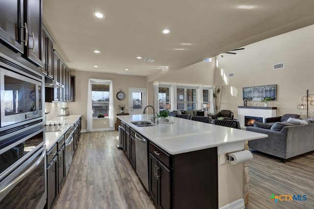 kitchen with light countertops, light wood-type flooring, stainless steel appliances, and a sink