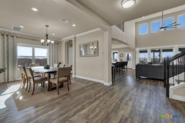 dining area with visible vents, dark wood finished floors, and ceiling fan with notable chandelier