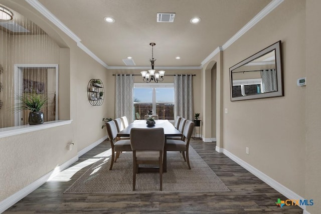 dining room with visible vents, dark wood-style flooring, an inviting chandelier, and ornamental molding