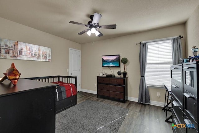 bedroom featuring a ceiling fan, baseboards, and wood finished floors