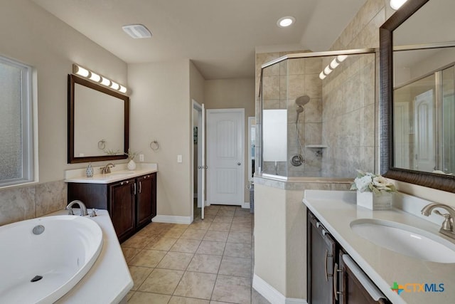 full bathroom featuring a sink, two vanities, a shower stall, and tile patterned floors