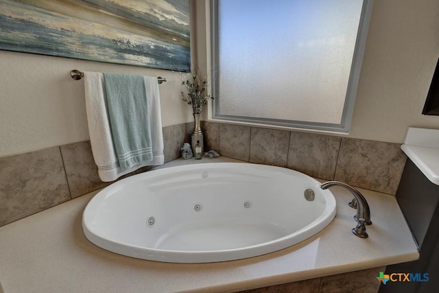 bathroom featuring a wealth of natural light and a tub with jets