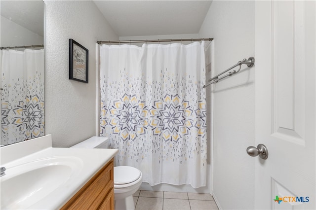 full bath featuring tile patterned floors, toilet, vanity, and a textured wall