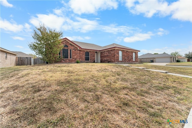 single story home with a front yard, a garage, fence, and brick siding