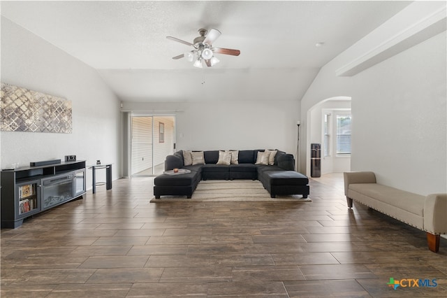 living area with a ceiling fan, lofted ceiling, wood finished floors, and arched walkways