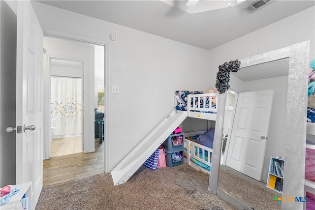 carpeted bedroom featuring visible vents and ceiling fan