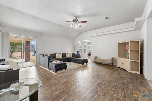 living area with a ceiling fan, wood finished floors, visible vents, lofted ceiling, and arched walkways