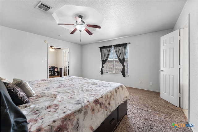 carpeted bedroom with visible vents, baseboards, a textured ceiling, and a ceiling fan