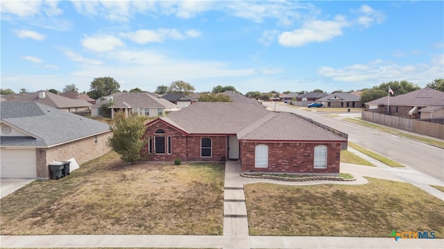 view of front of home with driveway, a residential view, a front yard, a shingled roof, and brick siding