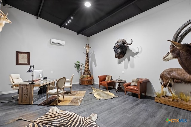 office area with hardwood / wood-style floors, rail lighting, and an AC wall unit