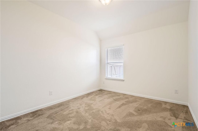 carpeted empty room with lofted ceiling