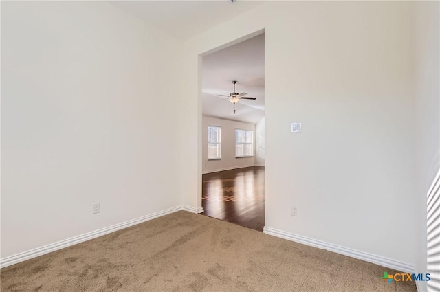 carpeted spare room featuring ceiling fan