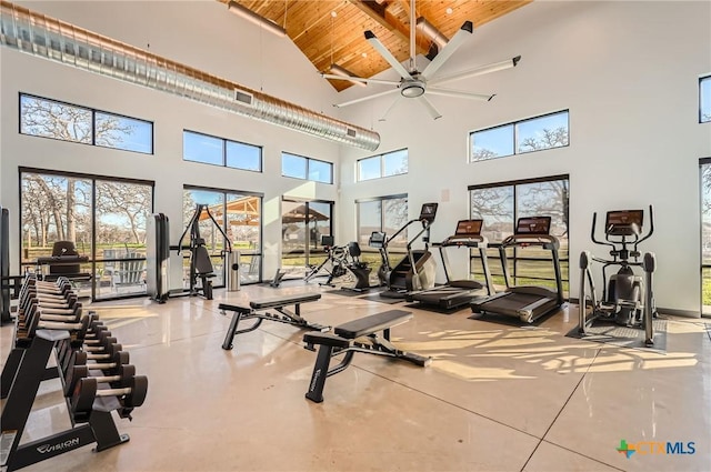 gym with ceiling fan, plenty of natural light, wood ceiling, and high vaulted ceiling