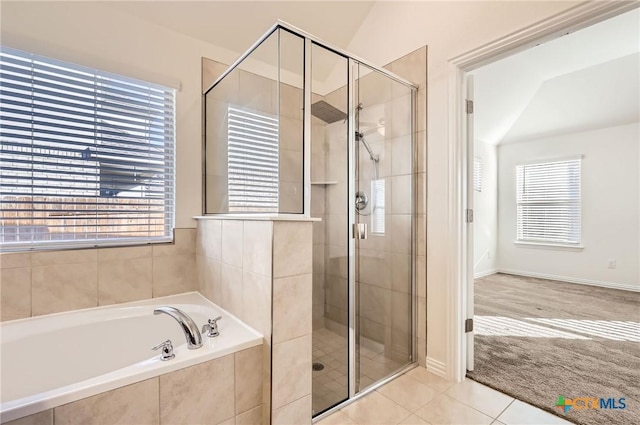 bathroom featuring independent shower and bath, tile patterned floors, and a healthy amount of sunlight