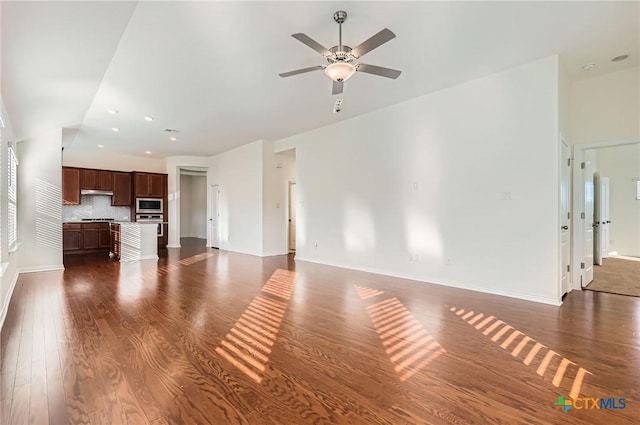 unfurnished living room with ceiling fan and dark wood-type flooring