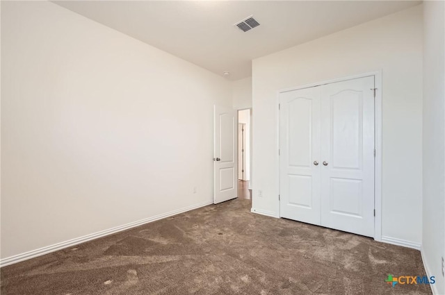 unfurnished bedroom featuring a closet and dark colored carpet