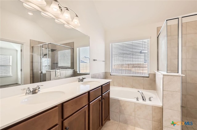 bathroom featuring vanity, separate shower and tub, vaulted ceiling, and tile patterned flooring