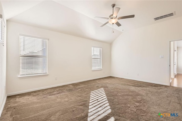 spare room with ceiling fan, lofted ceiling, and dark colored carpet