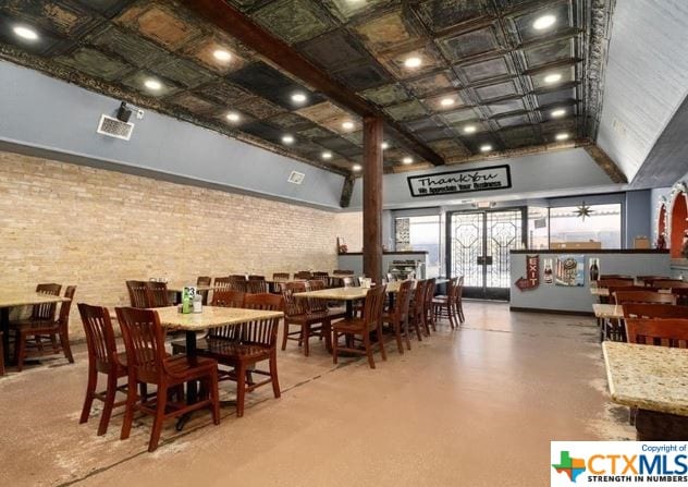 dining area featuring brick wall