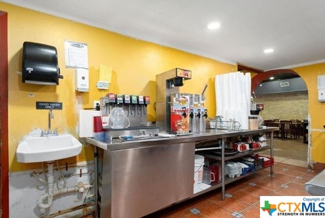 kitchen with stainless steel counters, sink, and tile patterned floors