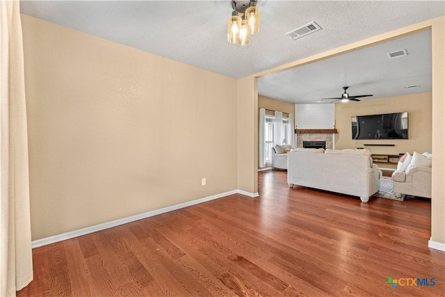 unfurnished living room featuring hardwood / wood-style floors, a textured ceiling, and ceiling fan