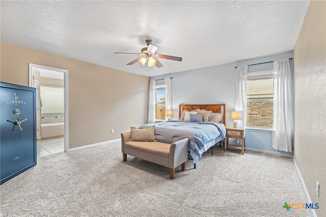 bedroom with ceiling fan, light colored carpet, a textured ceiling, and ensuite bathroom