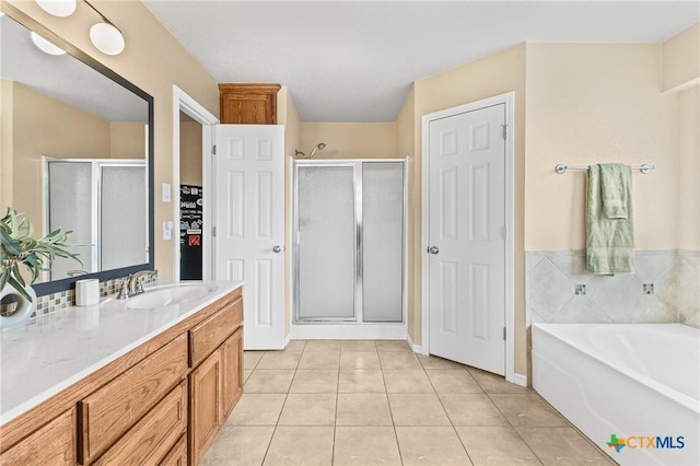 bathroom featuring tile patterned flooring, shower with separate bathtub, and vanity