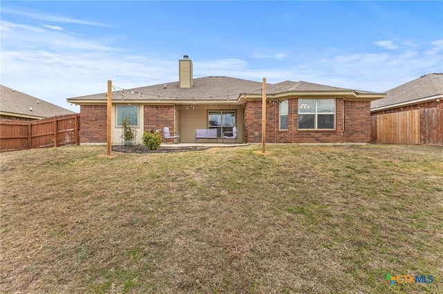 rear view of house with a lawn and a patio