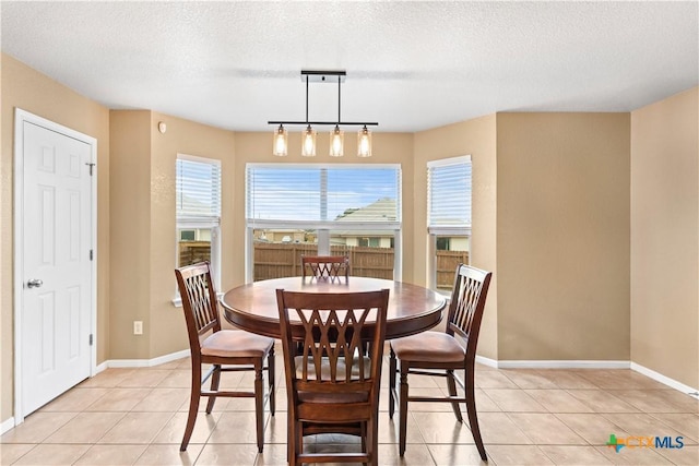 dining space with light tile patterned flooring and a textured ceiling